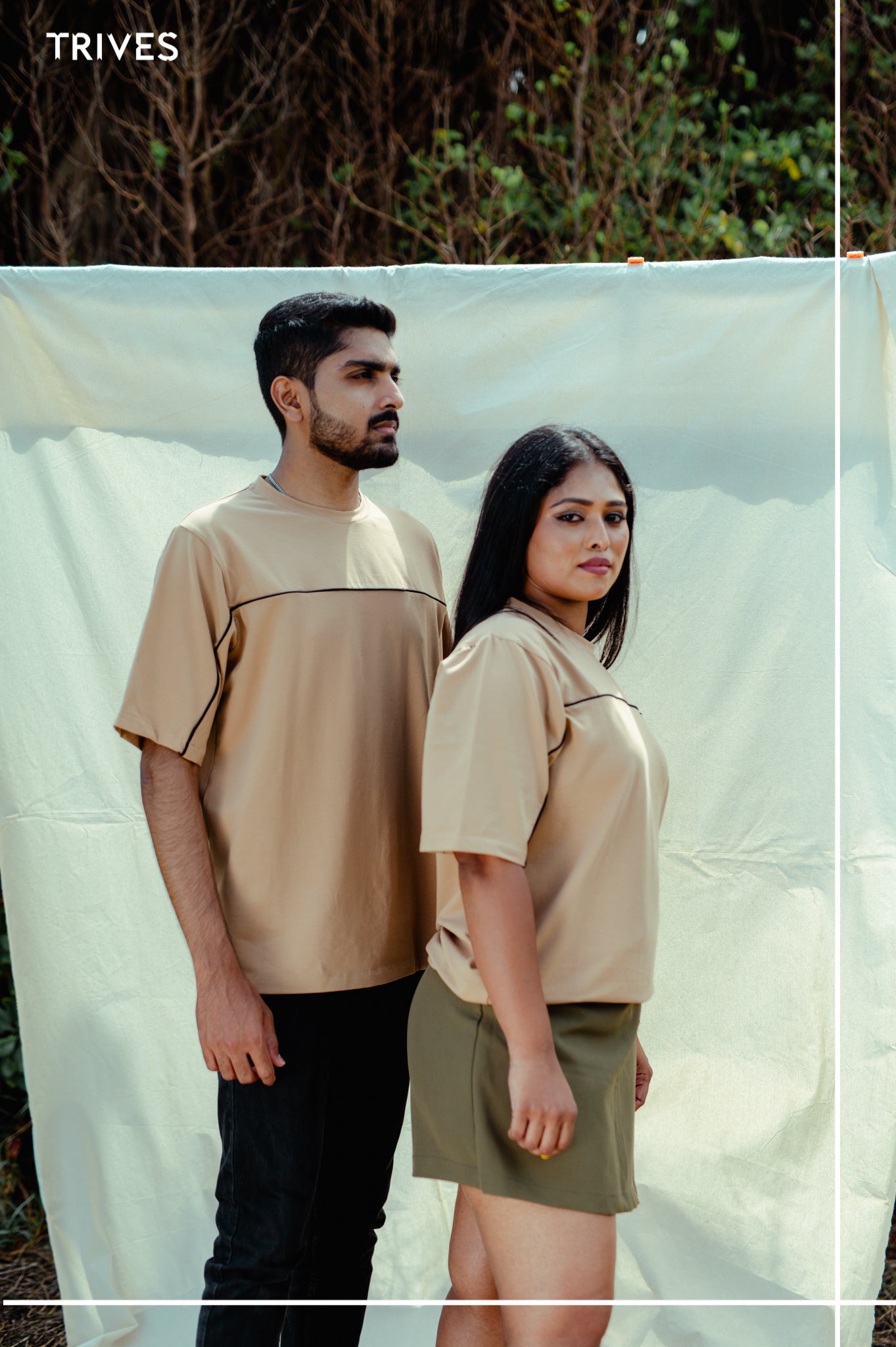 Two people wearing matching beige TRIVES horizon tee tops.