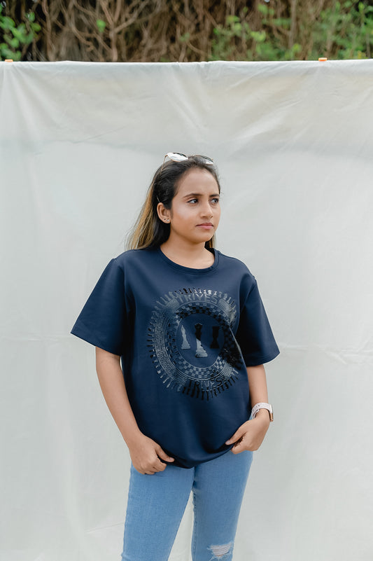 Woman wearing a navy blue t-shirt with a graphic design, standing against a plain background.